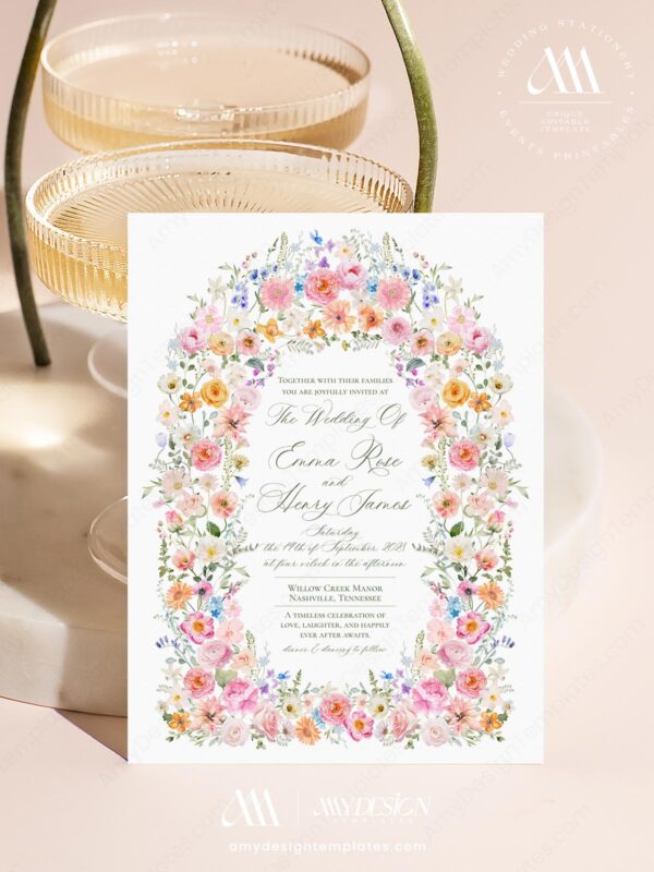 Wildflower watercolor wedding invitation with pink roses, peonies, lilies, daisies, botanical greenery, and elegant floral arch design